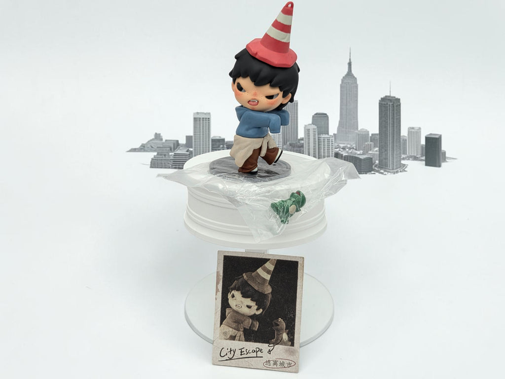 Momof2boyz Hirono Tamed Wildgrass figure with red and white striped cone hat, blue jacket, and tan pants, set against a cityscape backdrop.