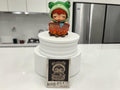 Momof2boyz Hirono Tamed Wildgrass figure of a character in a frog hoodie boiling a pot over a fire.
