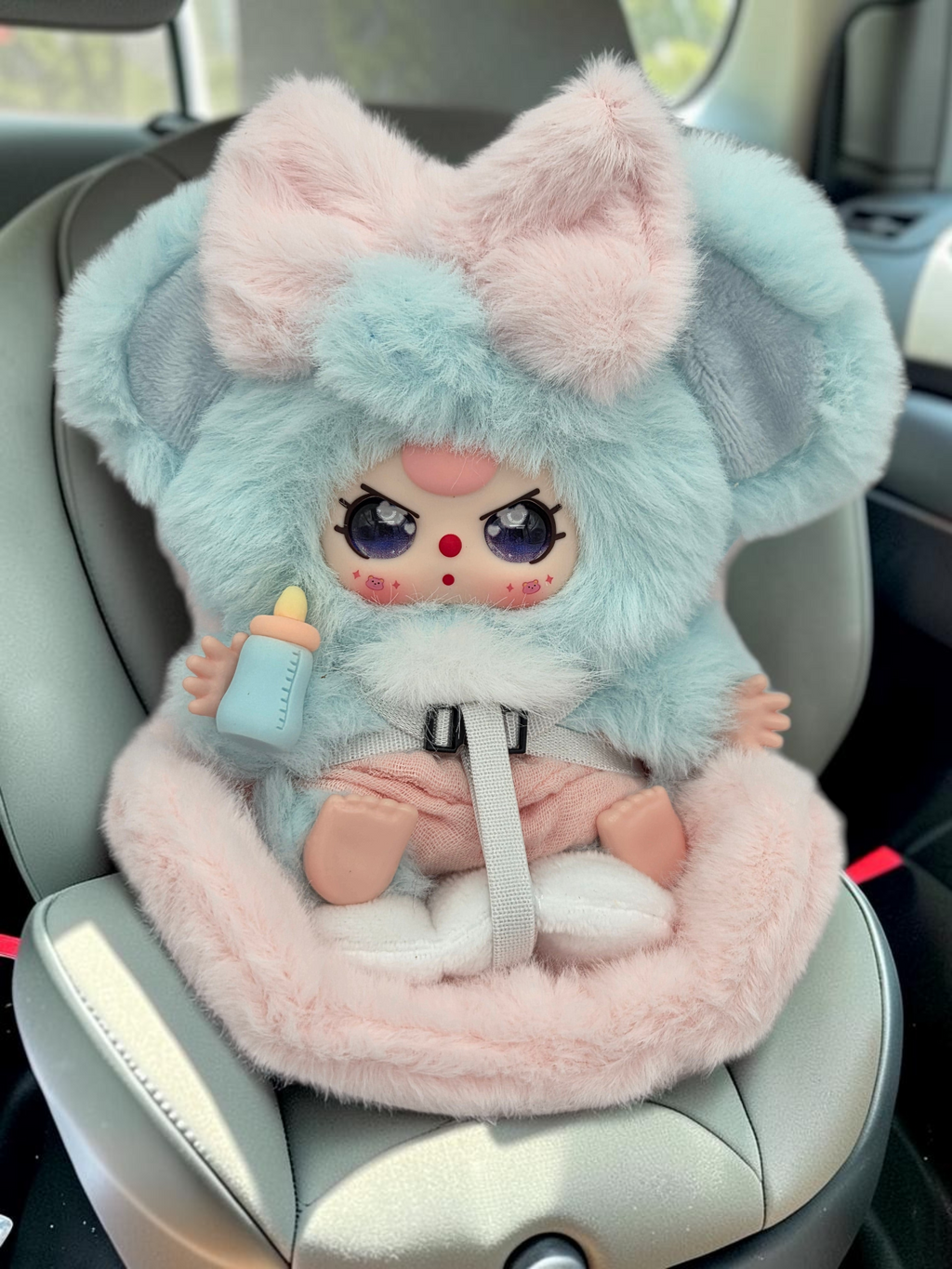 Momof2boyz Shop Baby Three BB3 collectible plush figure in a blue and pink fuzzy animal costume with a baby bottle.