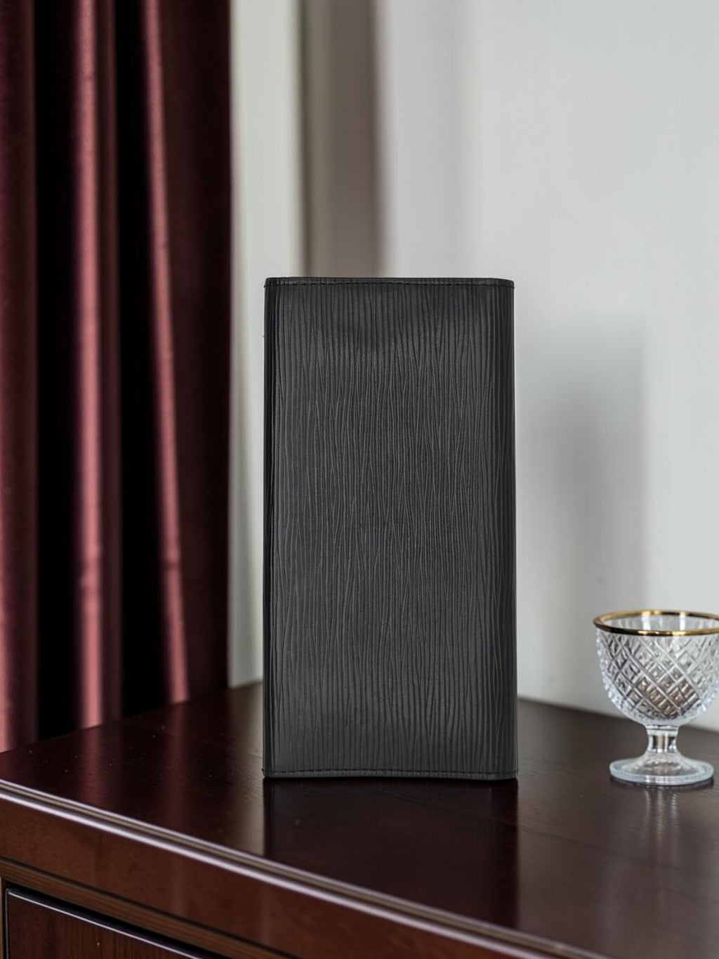 Momof2boyz Shop pre-owned black Louis Vuitton long wallet in textured Epi leather standing on a dark wooden surface.