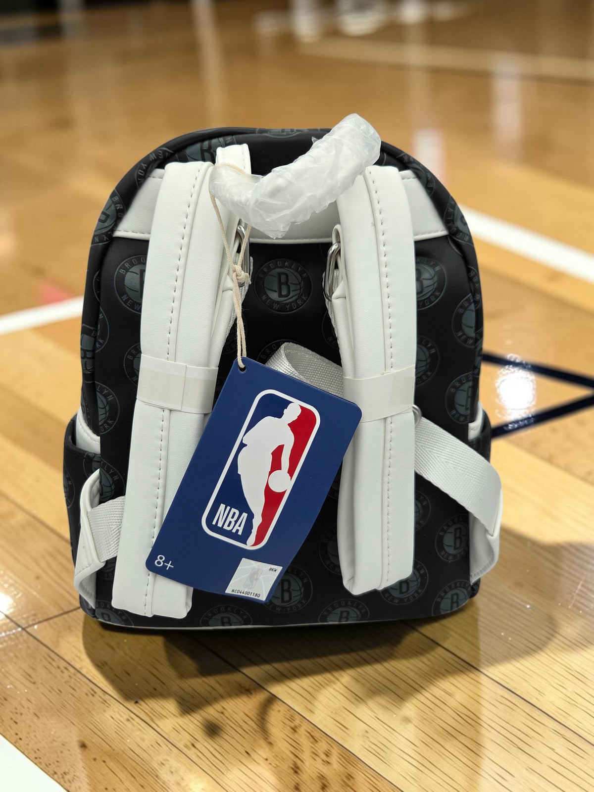 Momof2boyz Shop Brooklyn Nets Loungefly mini backpack with white straps and NBA tag on a basketball court floor