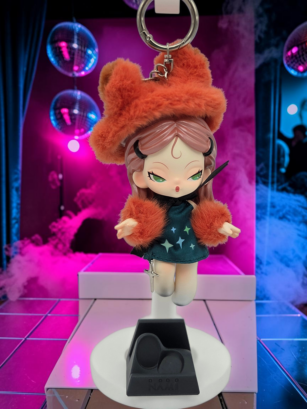 Momof2boyz Shop Dodo Nami Midnight Disco collectible keychain featuring a character in a fuzzy orange hat and dress