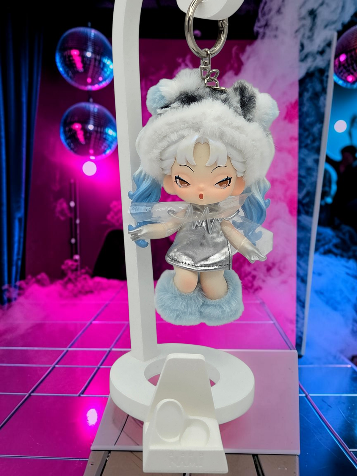 Momof2boyz Shop Dodo Nami Midnight Disco collectible keychain featuring a character in a silver dress and fuzzy hat.