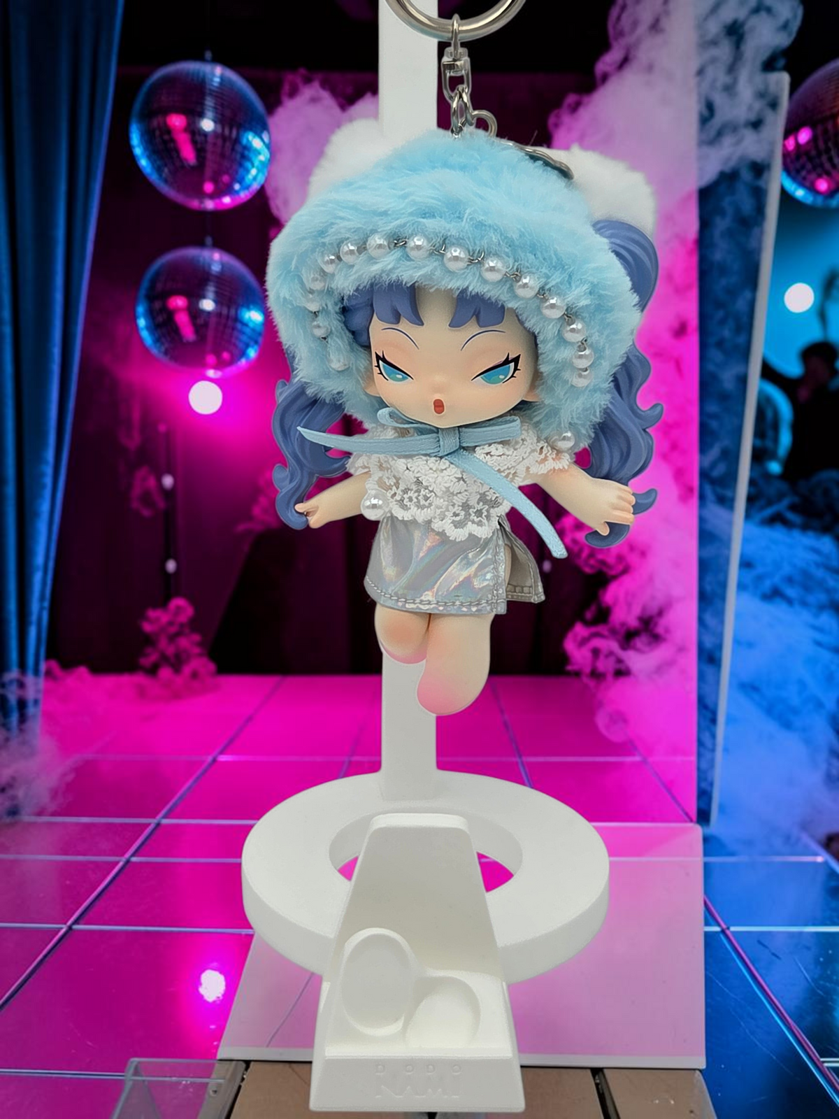 Momof2boyz Shop Dodo Nami Midnight Disco collectible keychain featuring a blue-haired character in a fuzzy hat.