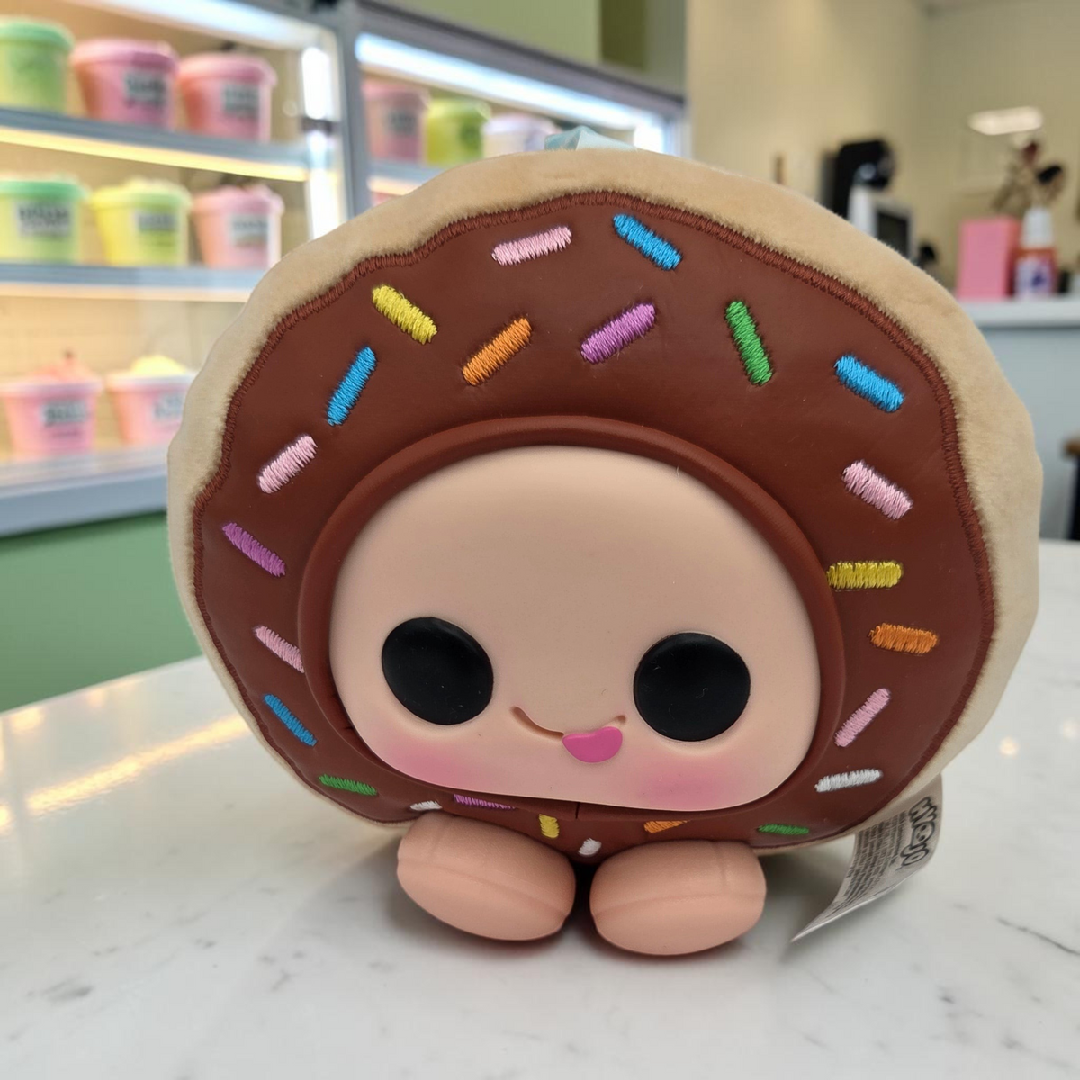 Momof2boyz Shop Hyejo plush toy shaped like a chocolate frosted donut with colorful sprinkles and a vinyl face.