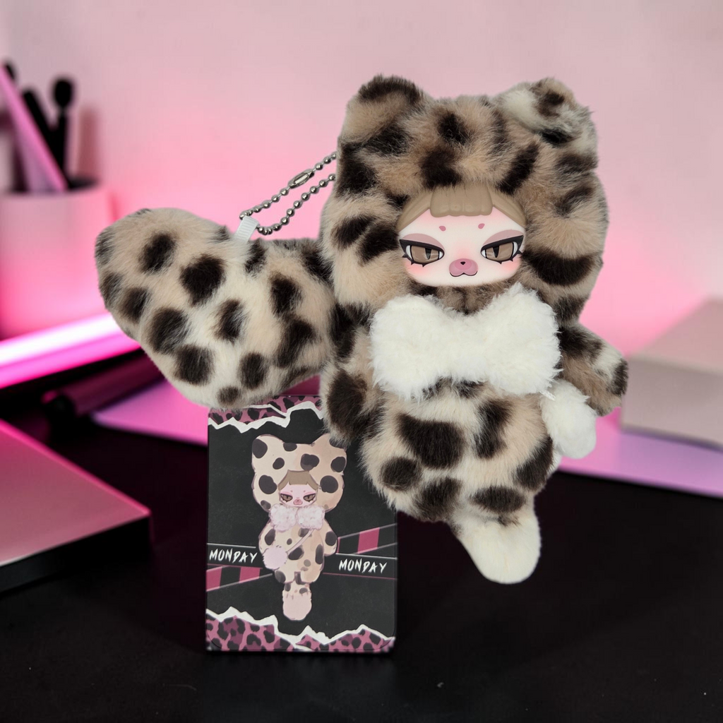 Momof2boyz Shop Monday plush keychain featuring a leopard print faux fur hood, white bow, and collector card.