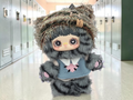 Momof2boyz Shop Maymei Kitten Academy Confirmed Cheesy Kitten plush figure with grey fur and blue vest in a hallway.