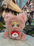 Momof2boyz Shop Migo Fairy Tales plush featuring a pink fuzzy pig character with a small house icon on its chest.