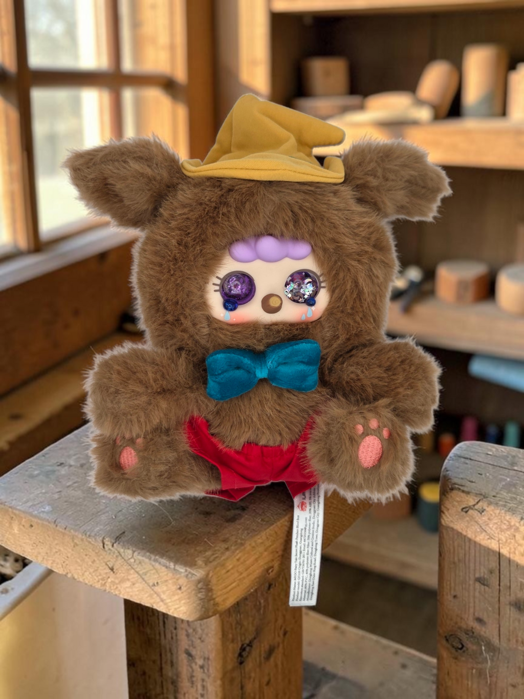 Momof2boyz Shop Migo Fairy Tales Confirmed A White Lie plush toy with brown fur, yellow hat, and blue bow tie.