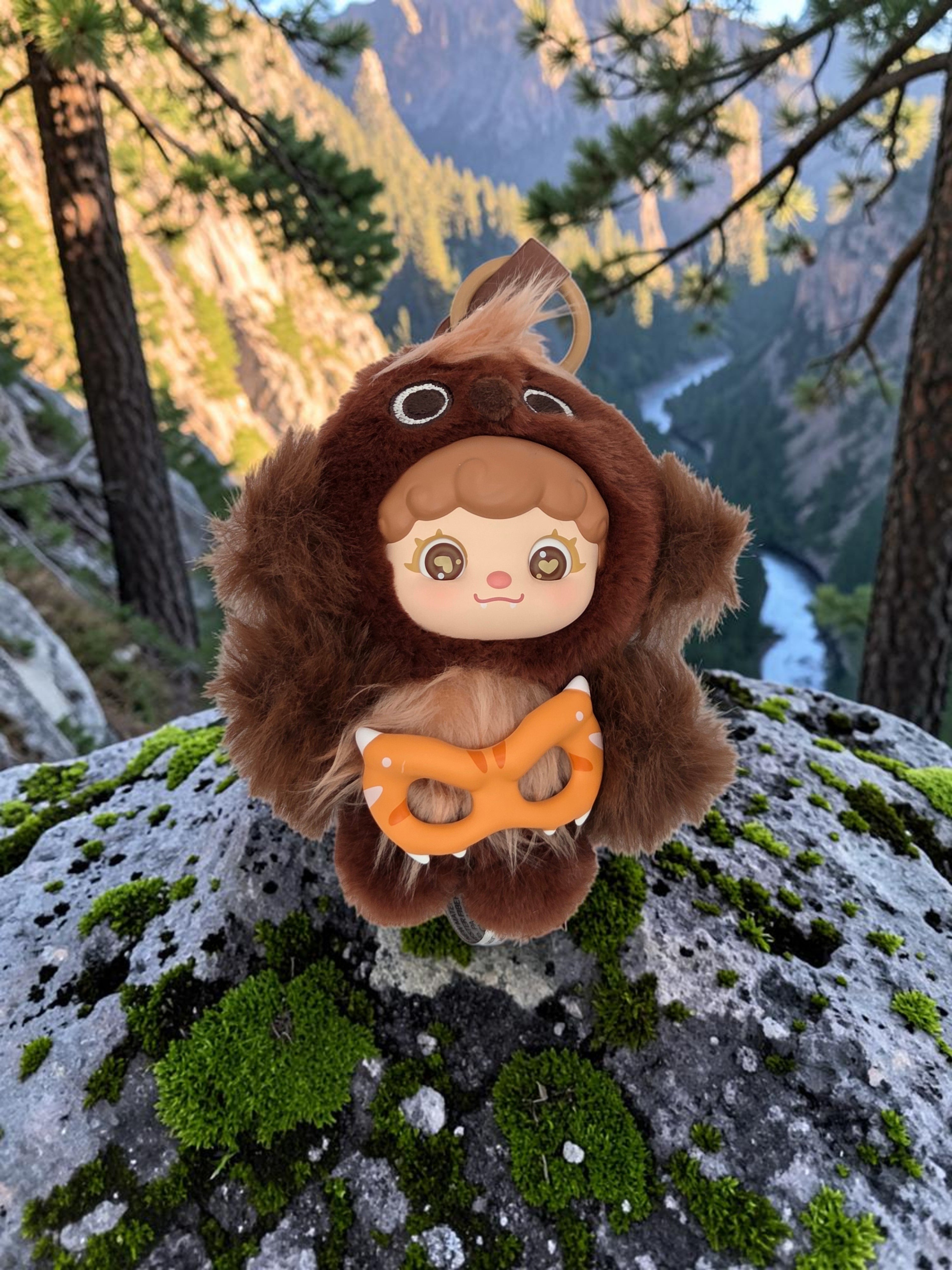 Momof2boyz Shop Mochi Little Monster plush keychain featuring a brown furry character with a tiger mask on a rock
