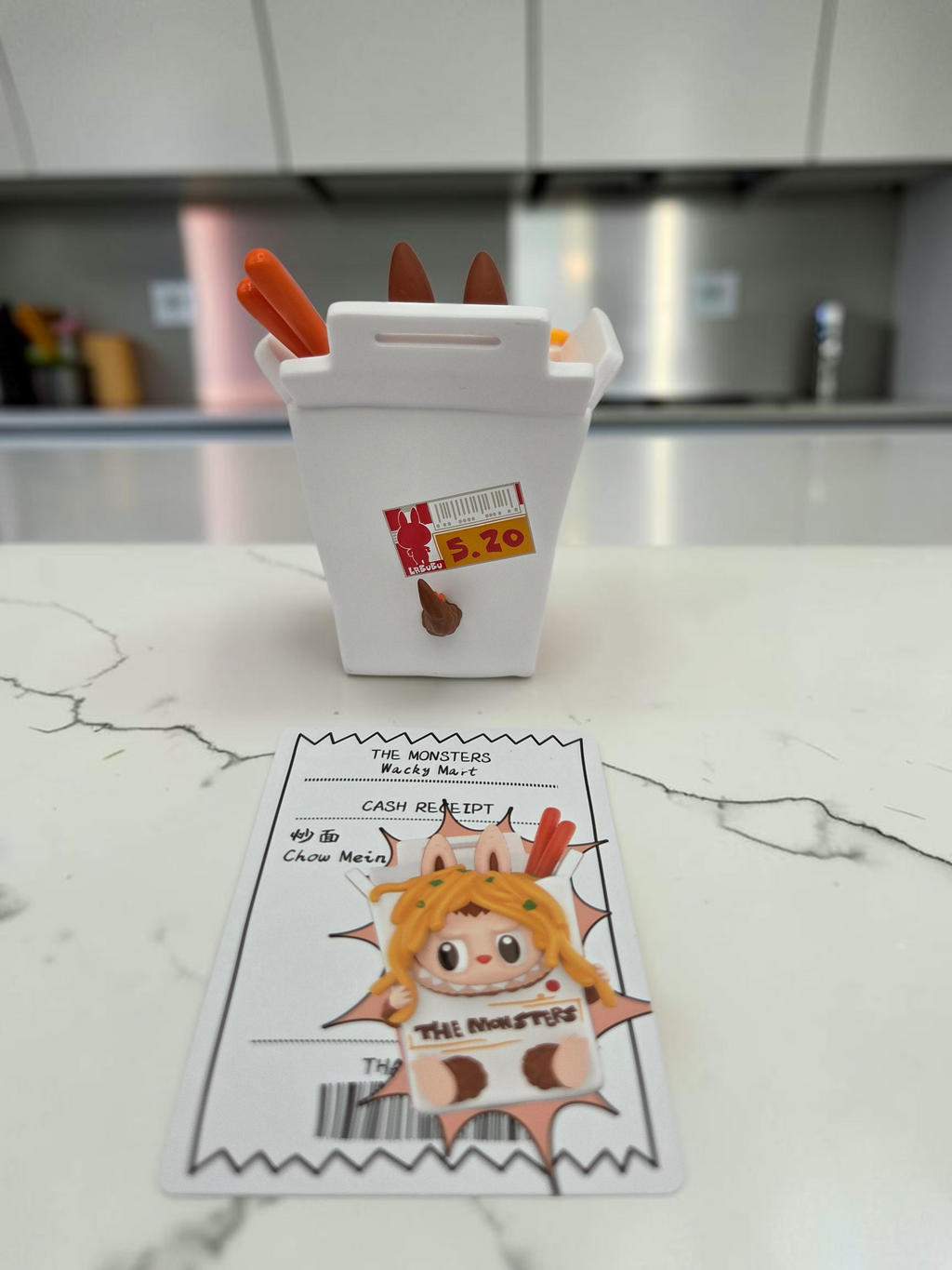 Momof2boyz Shop The Monster's Wacky Mart collectible figure in a white takeout box with chopsticks and receipt card.