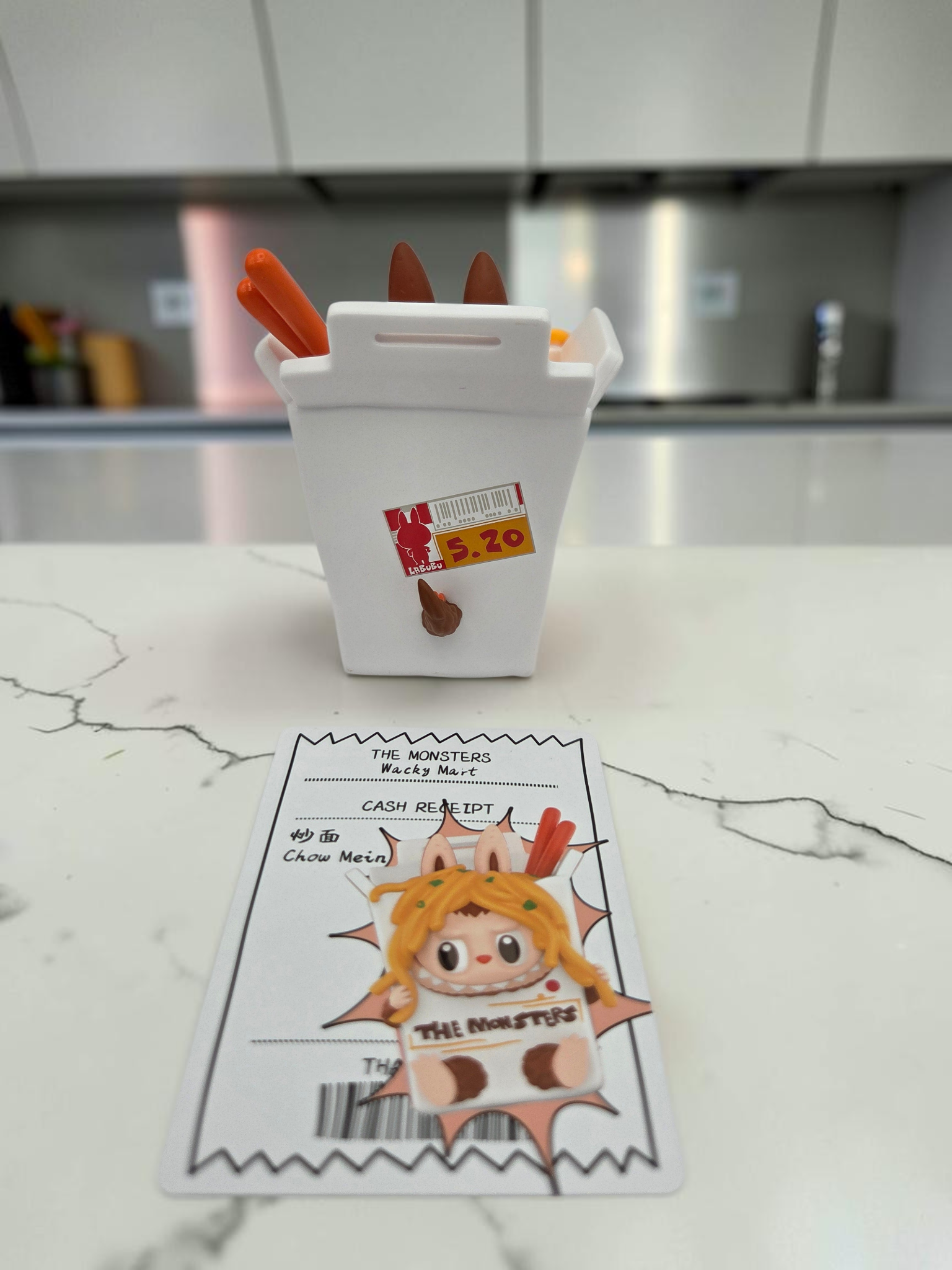 Momof2boyz Shop The Monster's Wacky Mart collectible figure in a white takeout box with chopsticks and receipt card.