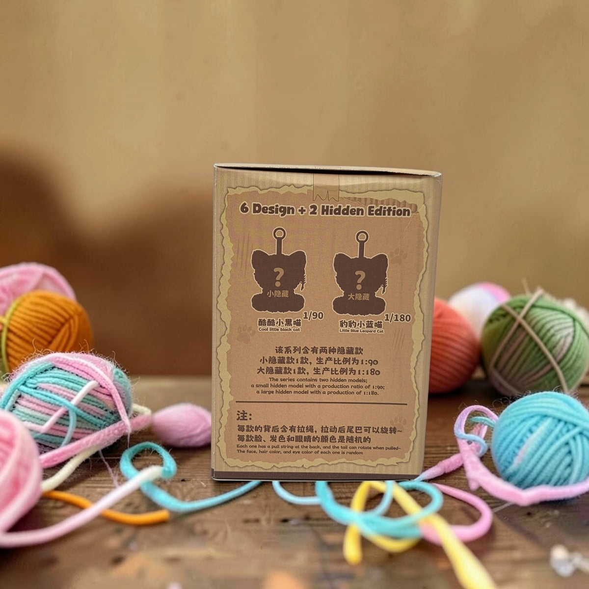 Momof2boyz Shop Naughty Kitty blind box packaging showing hidden edition details surrounded by colorful yarn balls