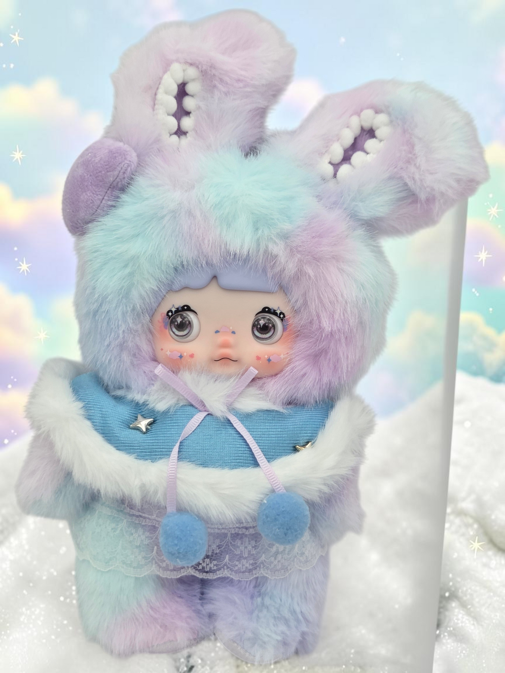 Momof2boyz Shop Nommi plush doll in a pastel blue and purple faux fur bunny hood with a blue cape and lace trim.
