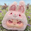Momof2boyz Shop Idol Plush first gen rabbit character with soft pink fur and large expressive eyes in a field.