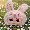 Momof2boyz Shop Idol Plush rabbit character with soft pink fur and large expressive eyes in a daisy field.