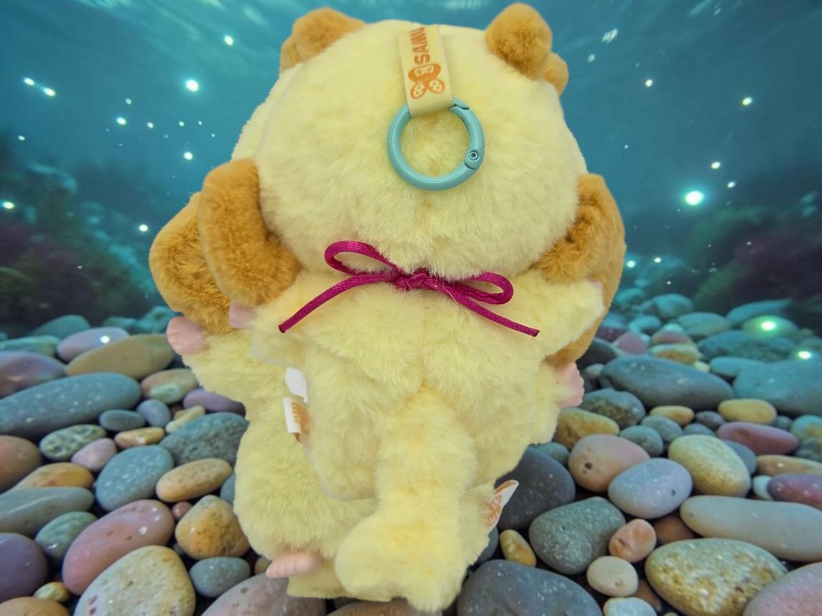 Momof2boyz Shop Samuel Ocean Spiny Porpoise plush figure in yellow and brown with a ribbon, back view.
