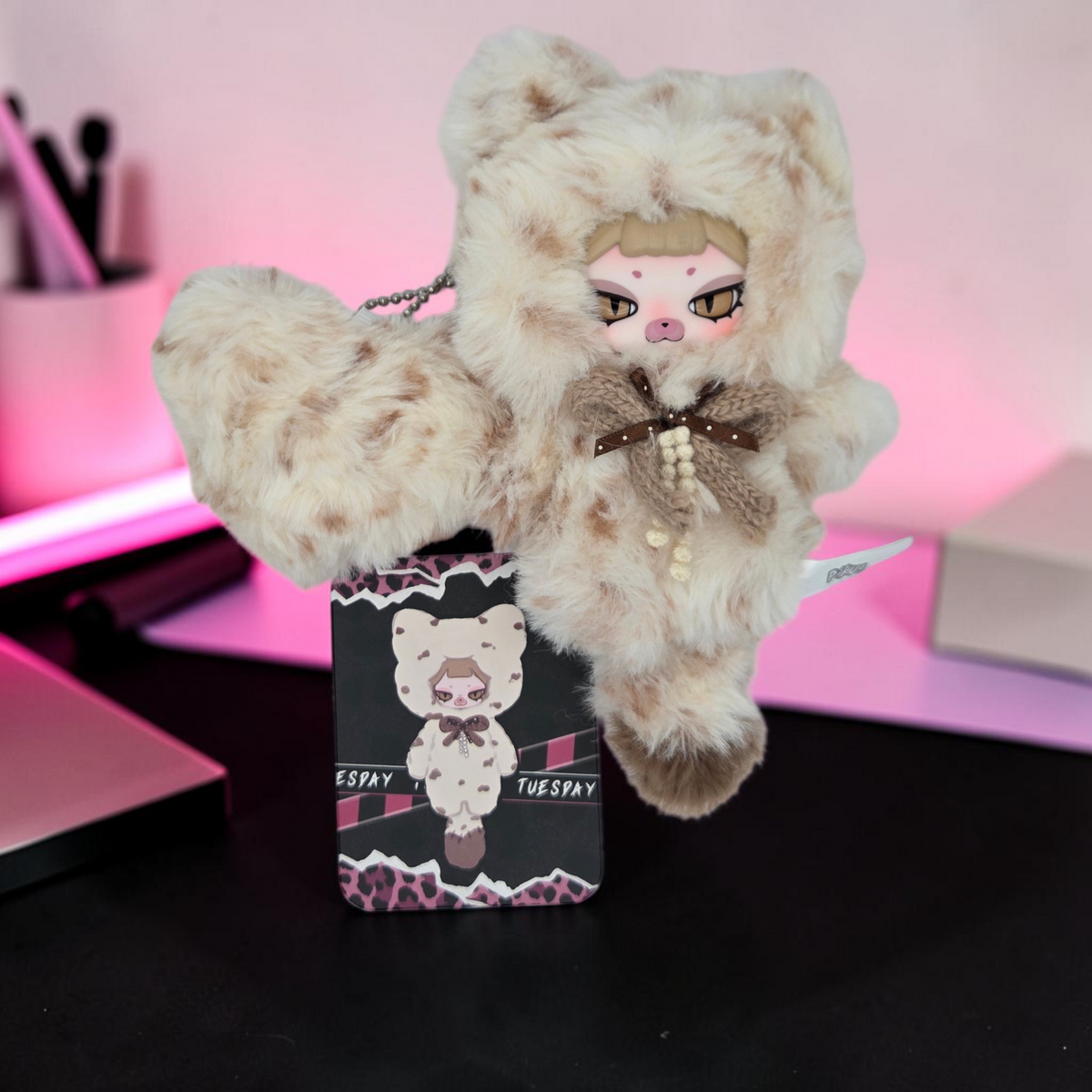 Momof2boyz Shop Tuesday plush keychain with leopard print faux fur hood, brown bow, and matching collector card.