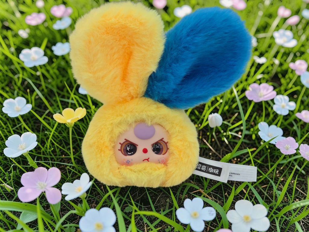 Momof2boyz Shop yellow and blue plush bunny collectible with fluffy ears and grumpy expression.